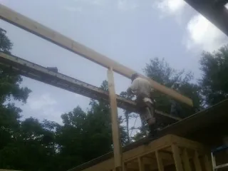 Carpenter setting a ridge beam over a new addition frame — Ice Dam Removal by Roofing Brothers in Pipe Creek