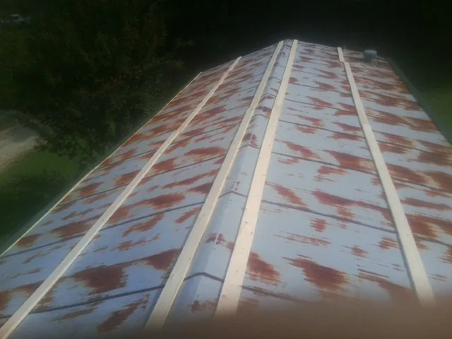 Rusted metal roof panels with new wood purlins before replacement — Storm Damage Roof Repair in Pipe Creek by Roofing Brothers