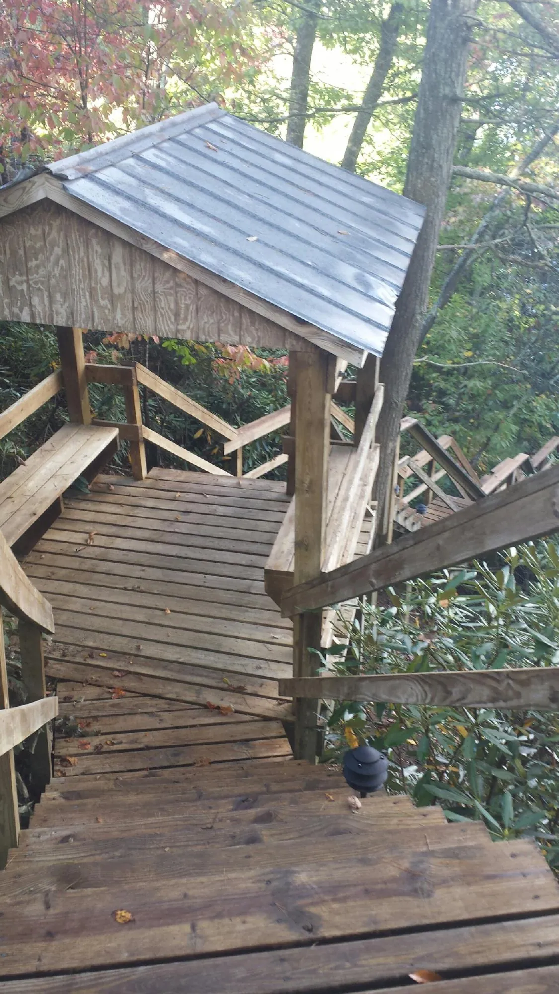Metal roofed shelter over wooden steps on a wooded walkway — Skylight Repair & Installation work by our crew in Pipe Creek