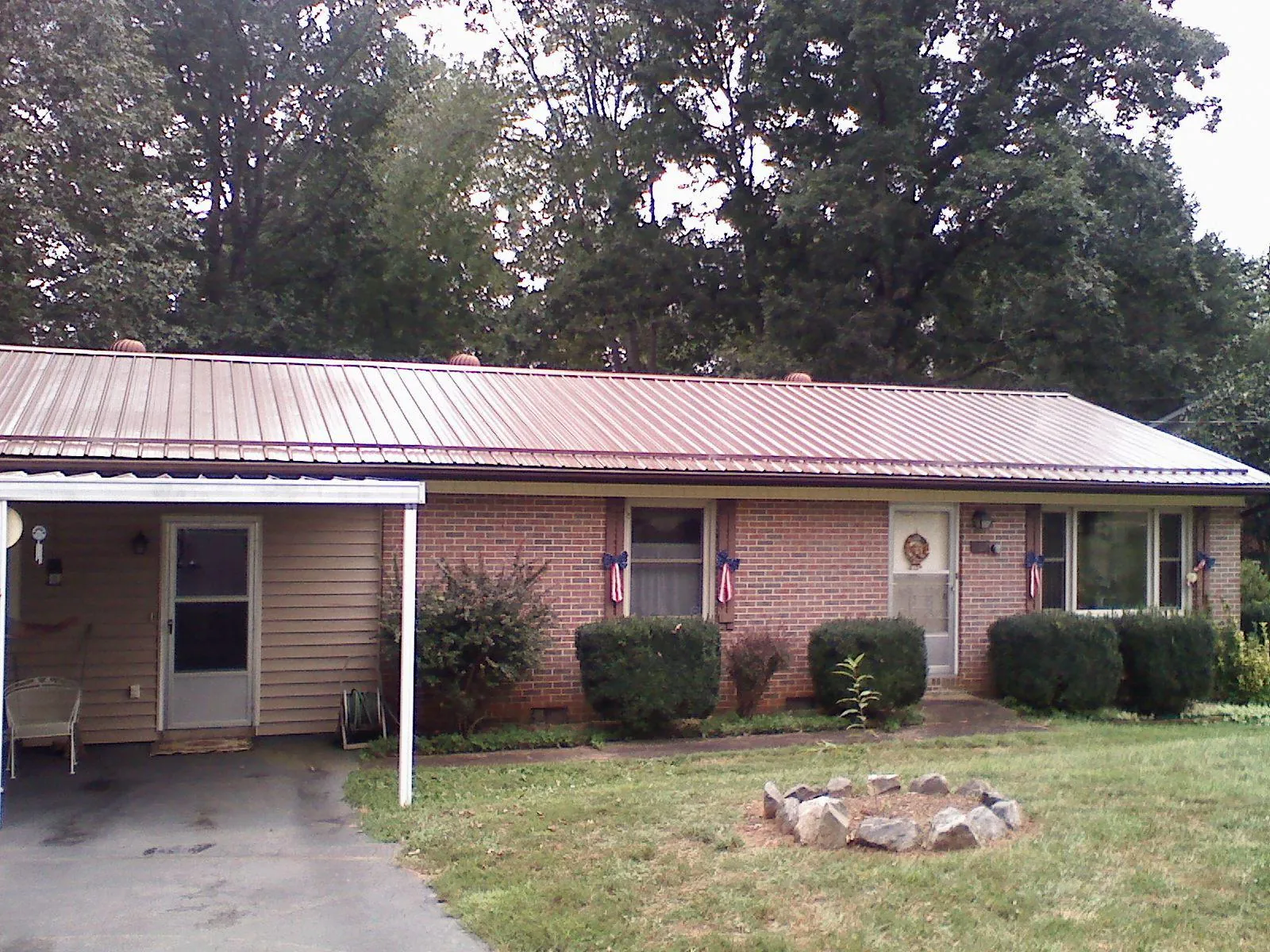 Bronze metal roof and carport on a brick ranch home — Roof Repair work by our crew in Pipe Creek