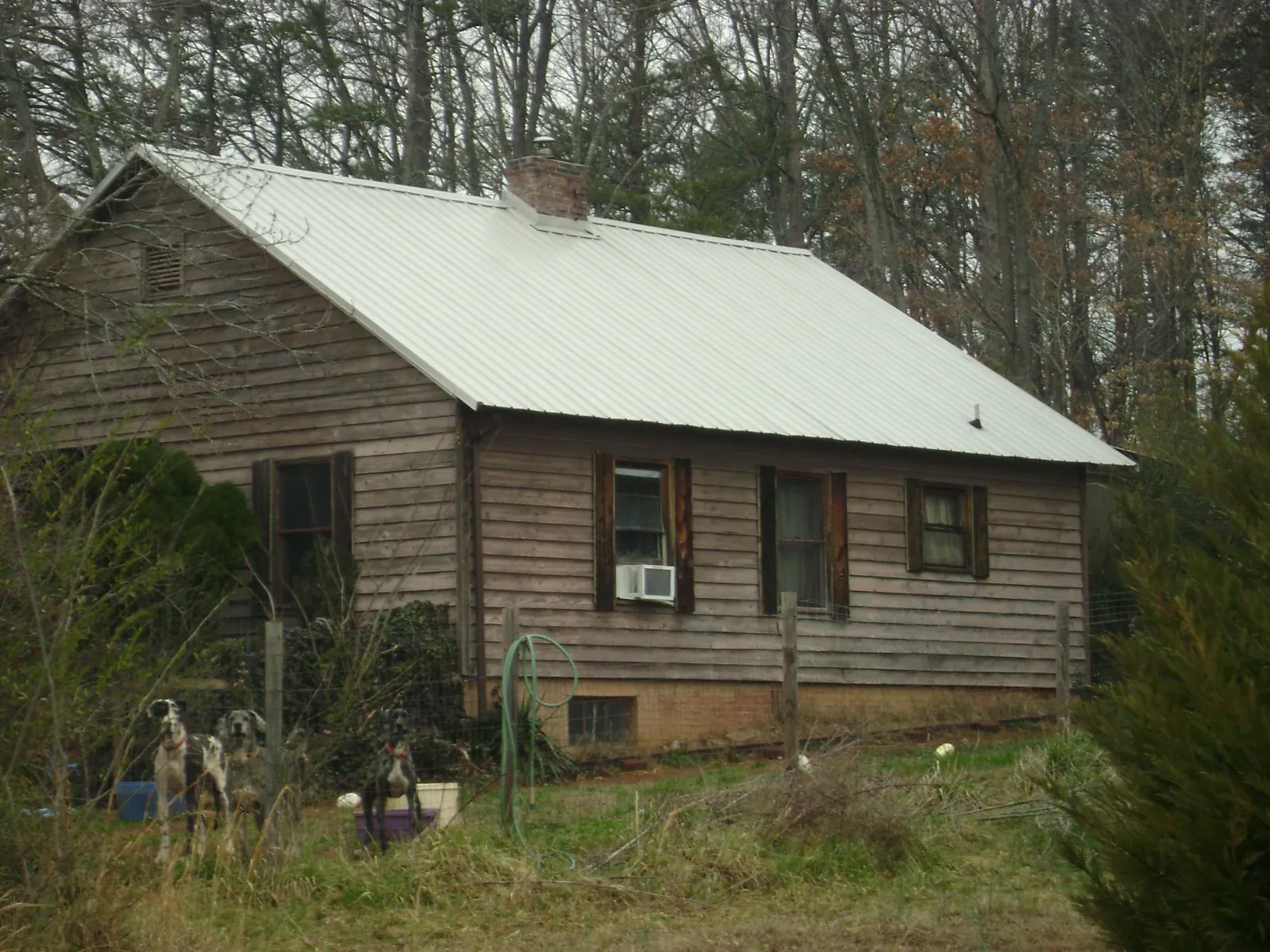 White metal roof on an old wood sided farmhouse, from a Metal Roof Installation job in Pipe Creek
